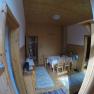 Esszimmer Ferienwohnung 2, © dmgrauszer Esszimmer mit Holzwänden, Tisch und Stühlen, Teppichen und Dekorationen.