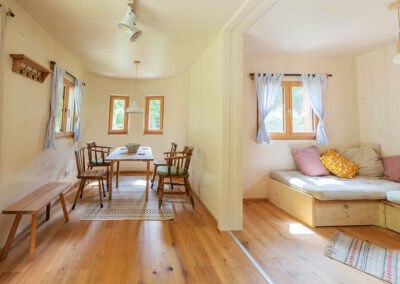 Modulhaus Huberto, © Carina Rebler Innenansicht eines gemütlichen Modulhauses mit Essbereich und Sitzecke.