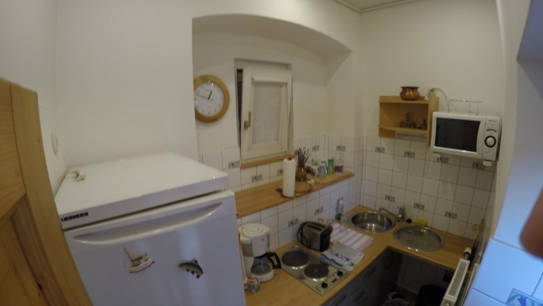 Küche Ferienwohnung 2, © dmgrauszer Kleine Küche mit Kühlschrank, Mikrowelle, Herd und Spüle.