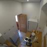Küche Ferienwohnung 2, © dmgrauszer Kleine Küche mit Herd, Kühlschrank und Holztür.