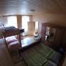 Schlafzimmer Ferienwohnung 2, © dmgrauszer Holzvertäfeltes Schlafzimmer mit Etagenbett, Doppelbett, Kleiderschrank und Fernseher.