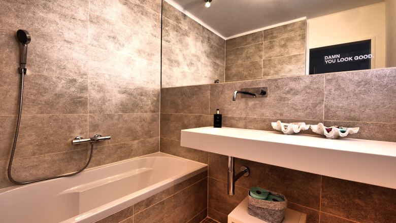 Badezimmer Top 3, © Daniela Sinadinoska Modernes Badezimmer mit Badewanne, Waschbecken und großem Spiegel.