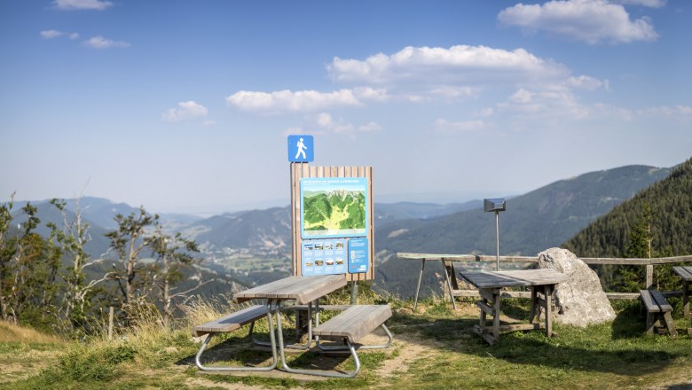 Wanderstartplatz Edelweißhütte Schneeberg, © Wiener Alpen, Foto: Franz Zwickl Picknicktische und Wanderschild mit Bergblick bei der Edelweißhütte am Schneeberg.