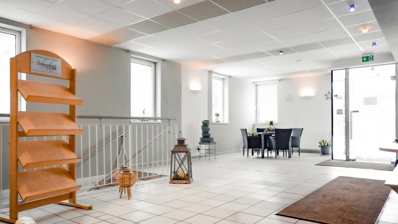 Empfangsbereich, © TheVerve-Agentur (theverve.at) Heller Empfangsbereich mit Tisch, Stühlen und Dekoration.