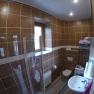 Bad/WC Ferienwohnung 2, © dmgrauszer Badezimmer mit braunen Fliesen, Dusche, Waschbecken, Toilette und Waschmaschine.