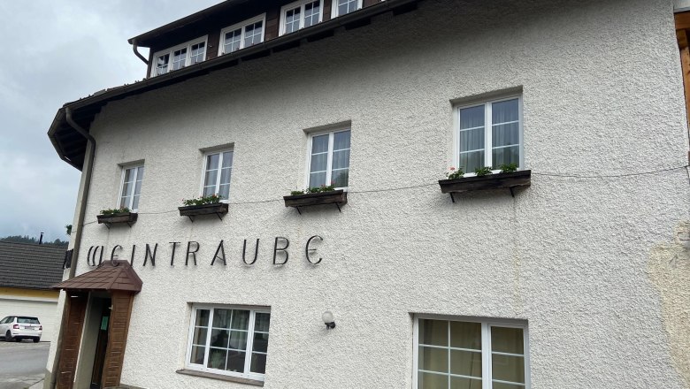 Apartment zur Weintraube, © Wiener Alpen Fassade eines Gebäudes mit dem Schriftzug 'Weintraube'.