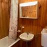 Badezimmer, © Wiener Alpen Holzvertäfeltes Badezimmer mit Badewanne, Duschvorhang, Waschbecken und Spiegelschrank.