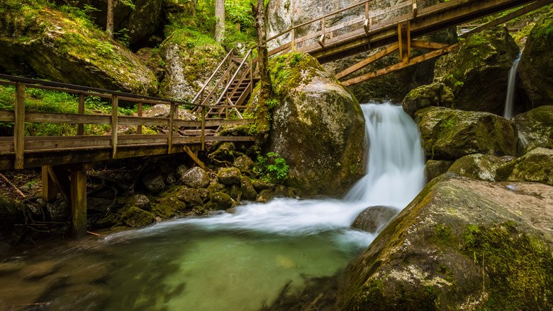 Muggendorf Myrafälle, © Wiener Alpen, Christian Kremsl Holzbrücken und Wasserfall in einer bewaldeten Schlucht.