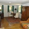 Gemütliches Gästezimmer mit Holzmöbeln, Teppich und Sofa.