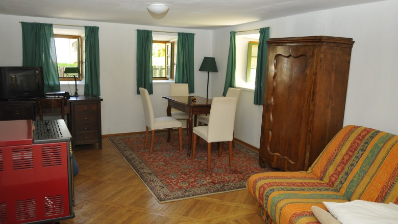 Gemütliches Gästezimmer mit Holzmöbeln, Teppich und Sofa.