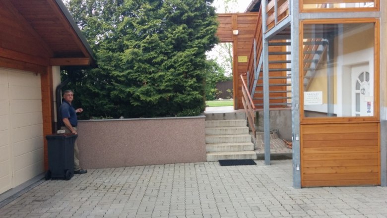 Hof mit Panoramatreppe und Mann neben Mülltonne.