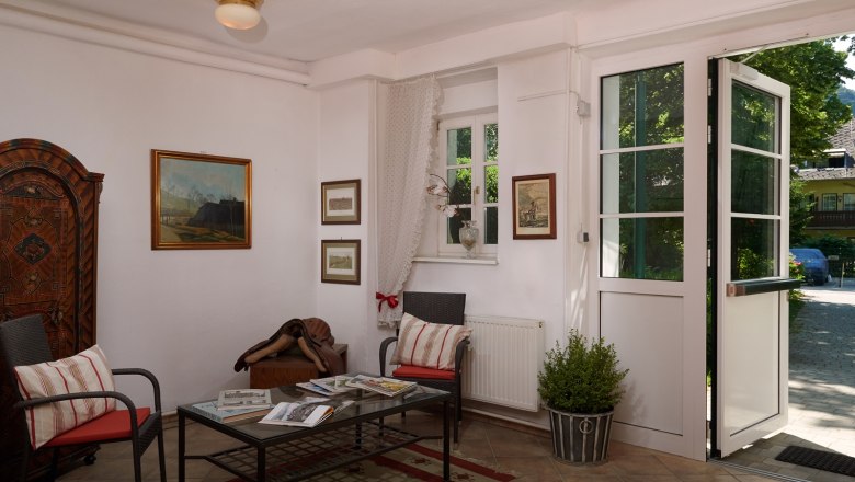 Gemütlicher Eingangsbereich mit Sesseln, Tisch und Dekorationen im Landhausstil.