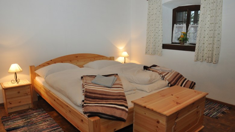 Gem&uuml;tliches Schlafzimmer mit Holzm&ouml;beln und Doppelbett.