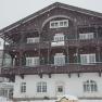 Ein großes, traditionelles Gebäude im Schnee, beschriftet mit 'Schneeberghof'.