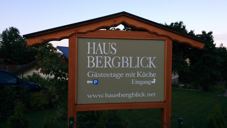 Schild mit der Aufschrift 'Haus Bergblick, Gästetage mit Küche'.