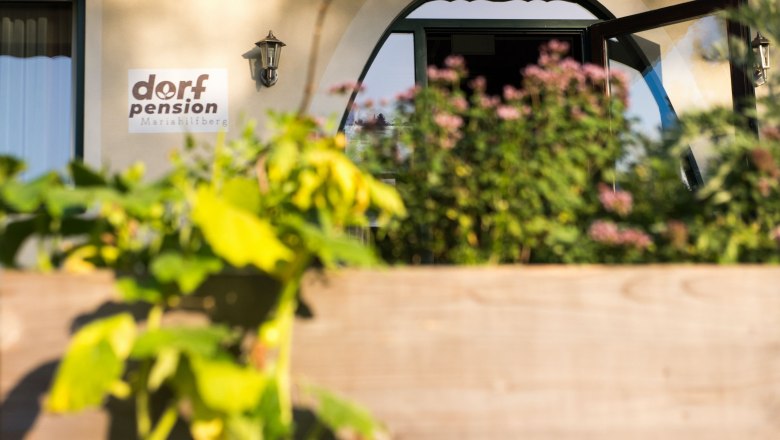 Eingang der Dorfpension Mariahilfberg mit Pflanzen im Vordergrund.