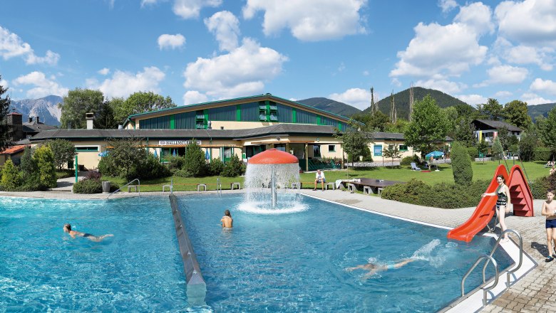 Freibad Puchberg mit Schwimmbecken, Rutsche und grüner Umgebung.