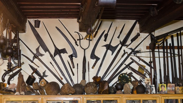 Wand mit historischen Waffen und Artefakten im Heimatmuseum.