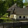 Ein traditionelles Gästehaus mit Holzzaun und Garten, umgeben von Bäumen.