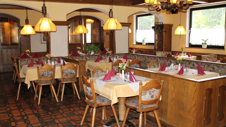 Gemütliches Restaurant mit Holzmöbeln und gedeckten Tischen.