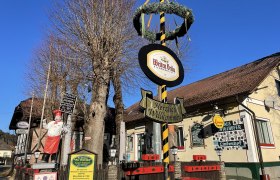 Gasthaus Lindenhof in Pernitz mit Maibaum und Schildern.