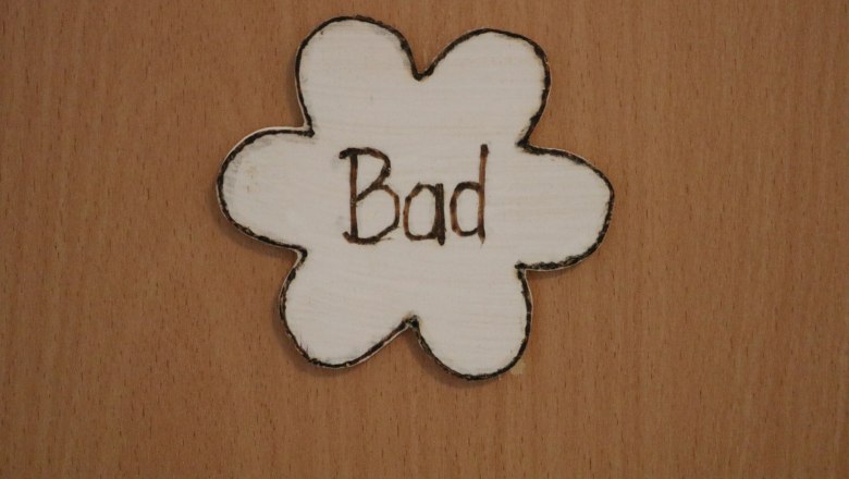 Holzschild in Blumenform mit der Aufschrift 'Bad'.