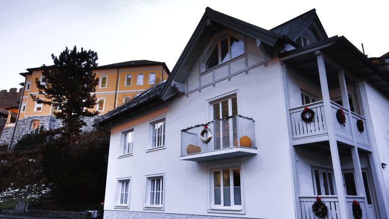 Hausansicht, © Daniela Sinadinoska Zwei Häuser, eines weiß mit Balkon, das andere gelb, mit Dekoration.