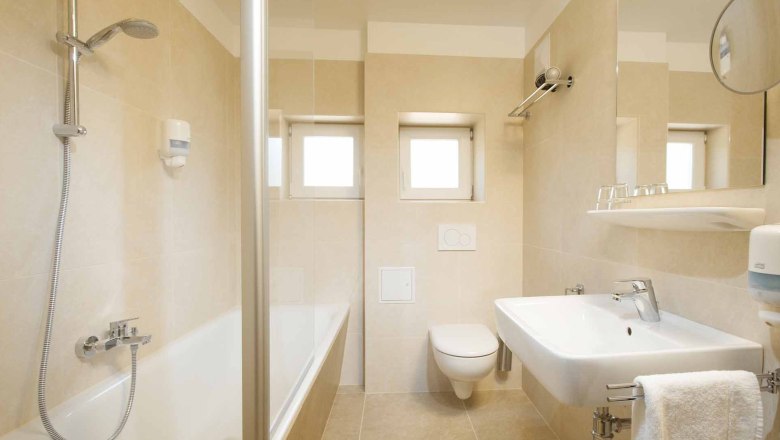 Modernes Badezimmer mit Badewanne, Waschbecken und Toilette.