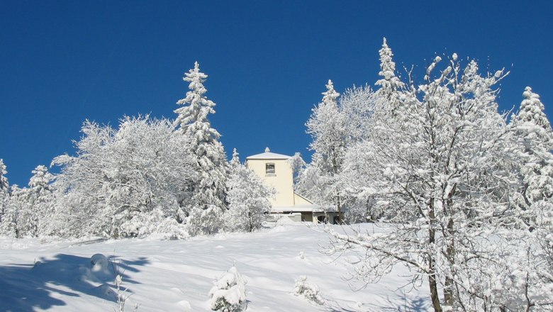 Verschneite Landschaft mit einem Geb&auml;ude im Naturpark Hohe Wand.