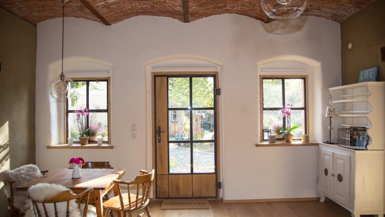 Heller Essbereich mit zwei Fenstern und Holz-Glastüre