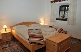 Gem&uuml;tliches Schlafzimmer mit Holzm&ouml;beln und Doppelbett.