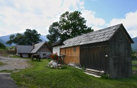 Traditionelle Holzgebäude mit Bergen im Hintergrund.