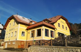 Gelbes Gebäude mit rotem Dach und Schriftzug 'Michlwirt'.