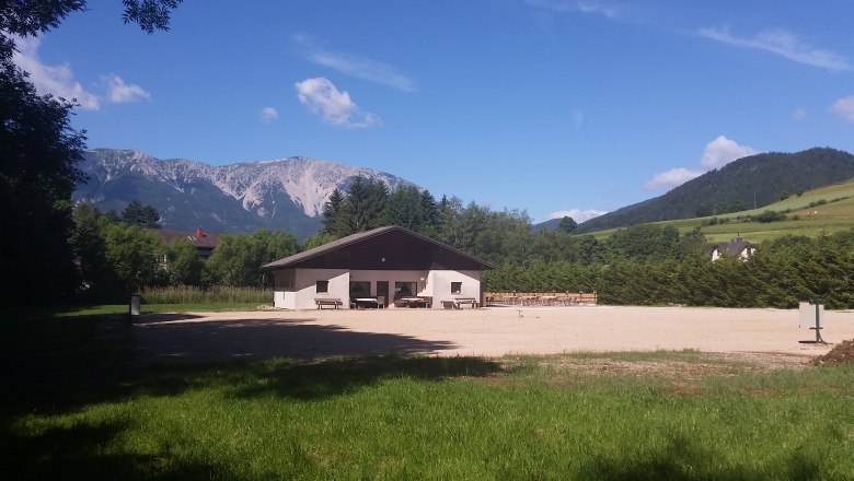 Ein Geb&auml;ude auf einem Campingplatz mit Blick auf einen Berg im Hintergrund.