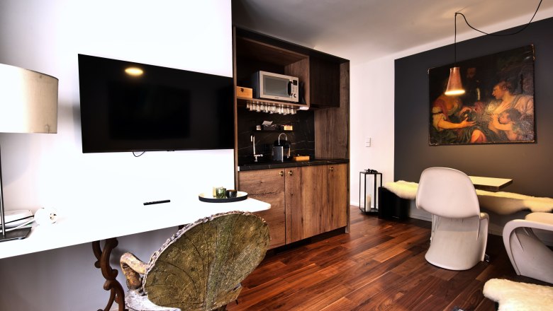 Moderne K&uuml;che mit Holzelementen, Flachbildfernseher und Essbereich.