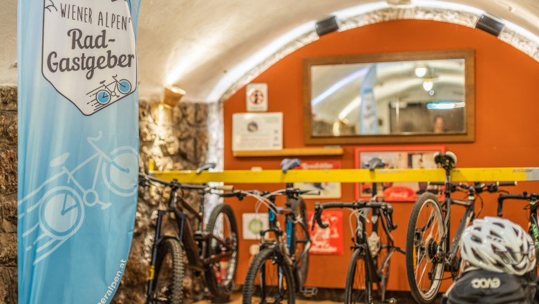 Fahrradgarage mit Fahrrädern und einem Banner der Wiener Alpen Rad-Gastgeber.